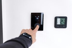 Smart thermostat with digital display mounted on a white wall in a modern home in 2026